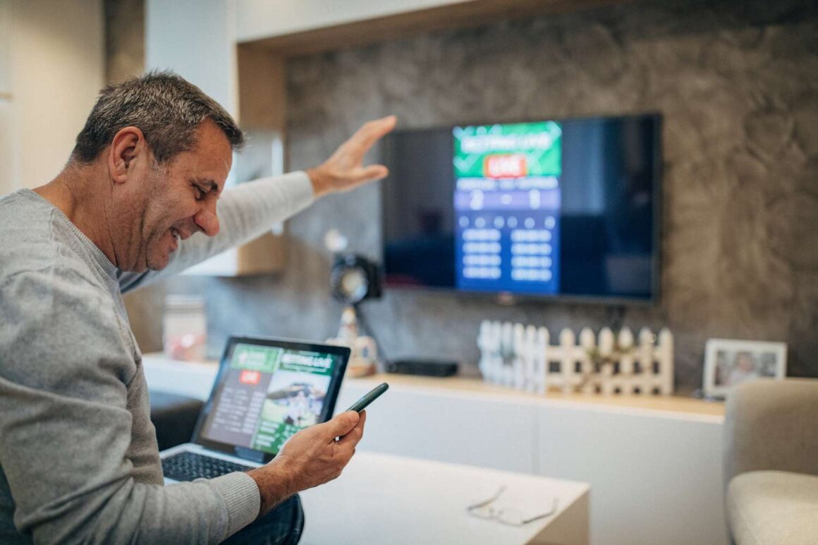 Sports bettor analyzing live odds on multiple screens